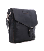 The Bed|Stü Venice Beach is a black full-grain leather messenger crossbody bag with a flap closure, buckle accent, and adjustable shoulder strap.