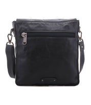 The Bed|Stü Venice Beach is a black full-grain leather crossbody with a front zipper pocket, adjustable strap, and a small rectangular patch at the bottom center.