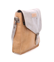 The Bed|Stü Venice Beach crossbody bag, crafted from tan and gray full-grain leather, features a front flap with buckle detail and an adjustable strap, shown against a white background.