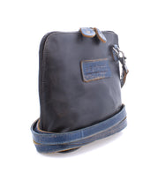 Introducing the Ventura by Bed|Stü—a small, rectangular black leather crossbody bag featuring a blue strap, zipper closure, exterior zip pocket, and an embossed logo patch on the front. This lightweight purse seamlessly blends style and functionality for everyday use.