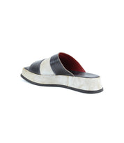 A single Bed|Stü Vext square-toe platform slide sandal with thick black and off-white bands and a striking red interior, displayed at an angle on a white background. This chic sandal boasts a leather-wrapped sole for added sophistication.