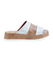 The Bed|Stü Vext platform slide sandal is displayed in a side profile against a white background, showcasing its brown and beige colorway, wide strap, thick leather-wrapped sole, and signature elevated design.