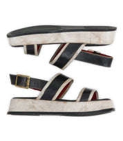 A pair of Bed|Stü Vice platform sandals in black and white, featuring gold buckles and an adjustable ankle strap, displayed side by side on a white background.