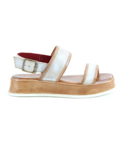 The Bed|Stü Vice sandal, displayed on a white background, features a white and tan platform design with a thick sole, adjustable ankle strap with buckle, and open toes.