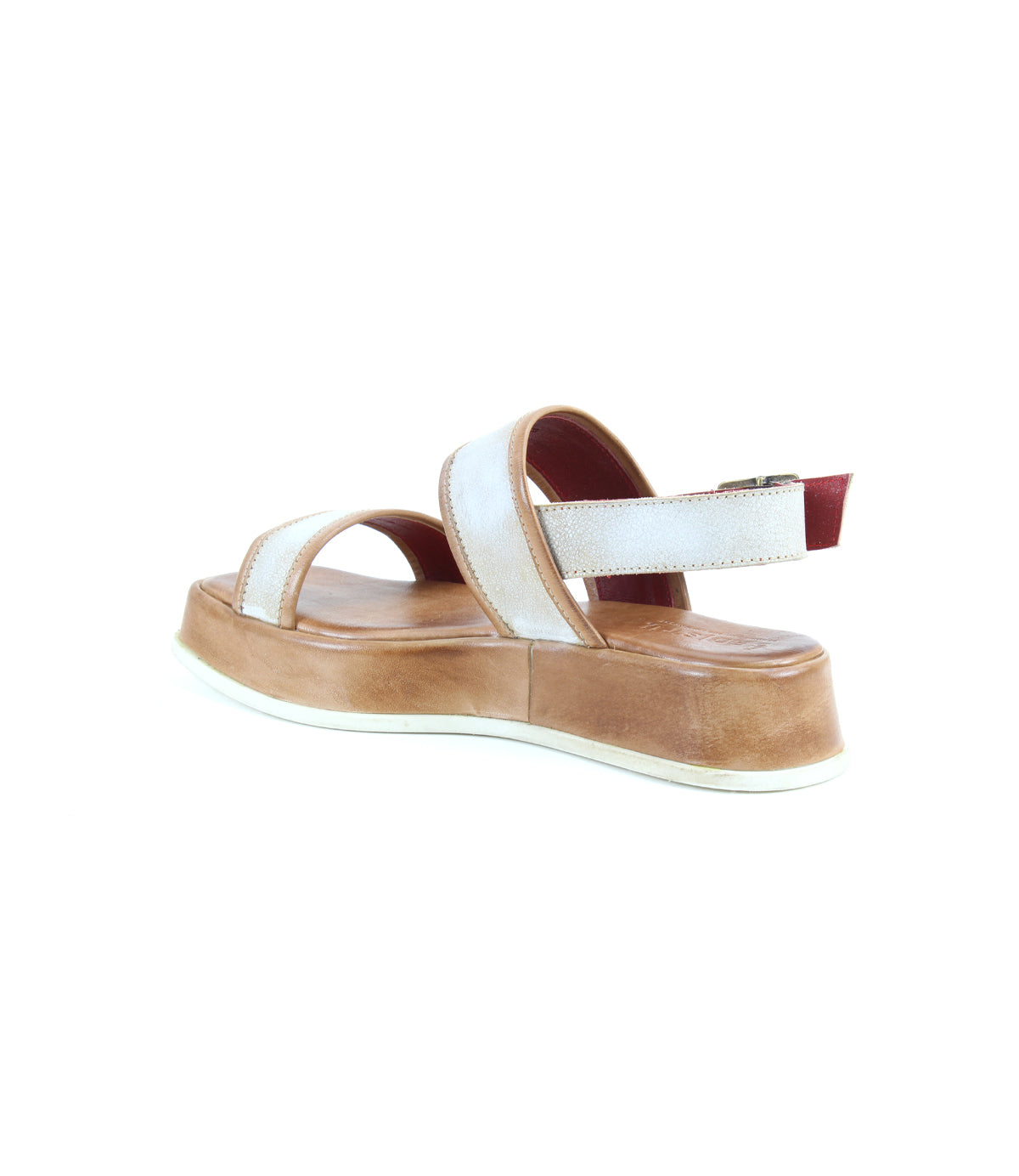 The Bed|Stü Vice features a single strappy design with white straps, a tan platform sole, and a red-accented adjustable ankle strap, showcased against a white background.
