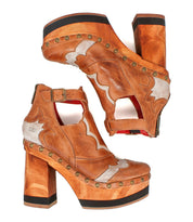 Step out in vintage-inspired style with the Viretta by Bed|Stü—a pair of brown leather high-heeled platform shoes featuring cutout details, silver accents, handcrafted wooden platform soles, black trim, and brass stud embellishments.