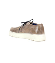 Bed|Stü’s Webmaster is a brown leather casual moc-toe sneaker featuring a black lace-up design and a white rubber sole, displayed angled from the back left side against a white background.
