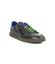 A single Bed|Stü Wizard low-profile leather sneaker in dark brown featuring blue, green, and purple laces, a blue inner lining, and visible crossover stitching, displayed on a white background.