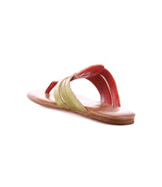 The Yoli sandal by Bed|Stü features a single flat leather design with a tan sole, a bold red strap over the top, and green crisscross straps, displayed against a white background.