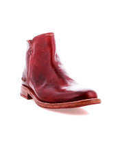 A single Yurisa red leather ankle boot by Bed|Stü, featuring a low wooden heel and a durable leather outsole, is shown from the front left side against a white background.