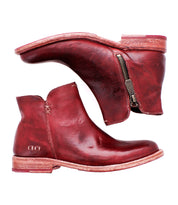 Introducing Yurisa by Bed|Stü: a pair of red leather ankle boots with side zippers, stacked wooden heels, and visible stitching, featuring a durable leather outsole. This handcrafted Yurisa boot is shown from both the side and sole views on a white background.