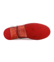 The image shows the red sole of the Bed|Stü Yurisa boot, featuring visible stitching along the edge and embossed branding patterns on the leather outsole.