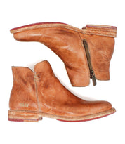 Two Yurisa ankle boots by Bed|Stü in brown, handcrafted with visible zippers and worn soles, featuring a durable leather outsole, shown side by side against a white background.