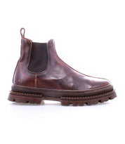 The Bed|Stü Accelerate is a brown leather Chelsea boot featuring elastic side panels, a pull tab, and a thick, rugged lug outsole that adds a modern edge to its classic silhouette, shown on a white background.