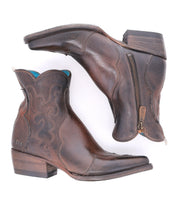 A pair of "Ace" brown full-grain leather ankle cowboy boots by Bed|Stü, featuring decorative stitching, low wooden heels, side zippers, and a slightly pointed toe, inspired by traditional boot making and displayed side by side on a white background.