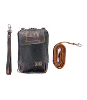 The Alelike by Bed|Stü is a compact, gently worn leather crossbody featuring a detachable wrist strap on the left and a rolled-up shoulder strap on the right, both fastened with metal clips—ideal for keeping your travel essentials organized in one stylish purse.