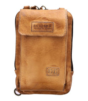 Introducing the Alelike by Bed|Stü—a compact crossbody bag crafted from tan leather, featuring a convenient front flap pocket, secure zipper top, and a distinctive "Bed|Stü" logo patch on the front. Perfect for carrying your travel essentials with ease and style.