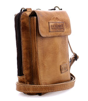 The Bed|Stü Alelike is a light brown leather crossbody bag featuring a flap closure, zippered compartment, and adjustable strap; this compact purse is perfect for travel essentials and showcases the "BED|STU" logo on the front flap.