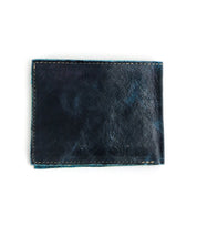 The Bed|Stü Amidala wallet, crafted in black leather with visible stitching, is displayed closed and lying flat against a white background.