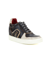 The Bed|Stü Andromeda sneaker is presented against a plain white background, featuring black and white leather uppers, a clean white sole, dark laces, contrast stitching, and a bold red inner lining for a city-ready look.