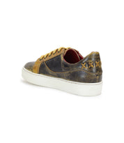 Introducing the Azeli by Bed|Stü: a brown and tan distressed leather sneaker featuring yellow laces, a white sole, a durable rubber outsole for all-day comfort, and three X-shaped stitches on the heel.