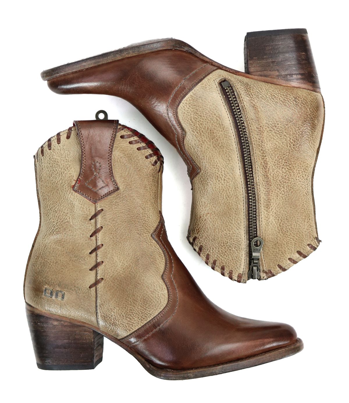 Introducing the Baila II by Bed|Stü: a pair of two-tone leather ankle boots crafted with artisanal precision. Featuring brown toes and heels contrasted by tan sides, decorative stitching, and practical side zippers, these Western-inspired boots—shown from both a side and bottom angle—are finished with refined detailing for a truly distinctive look.