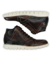 A pair of Bed|Stü Barton brown two-tone leather high-top sneakers with white textured, lightweight soles, displayed side by side with one shoe’s sole visible.