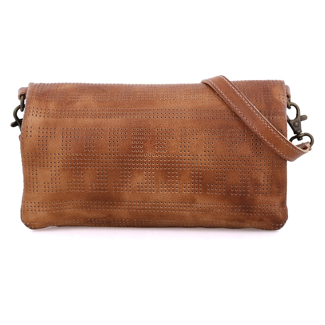 The Bed|Stü Bayshore is a brown leather clutch featuring a perforated pattern, metal hardware, and a detachable shoulder strap. Shown against a white background, this versatile accessory seamlessly transforms from a clutch into a crossbody bag, making it ideal for both everyday use and travel.