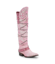 The Betting boot by Bed|Stü is a pink knee-high cowboy boot with white floral inlays and metal studs, featuring handcrafted leather construction, a pointed toe, and a low heel.