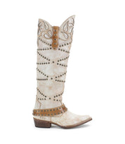 The Bed|Stü Betting boot is a tall, light brown handcrafted leather style featuring decorative stitching, studded harness accents, and a low heel, displayed in profile against a white background.