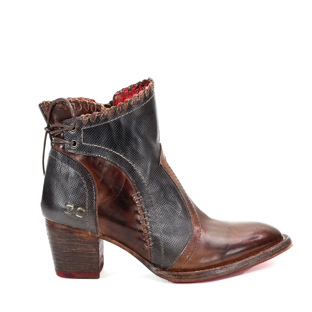 Introducing the Bed|Stü Bia: a single handcrafted ankle boot in brown and black premium vegetable-tanned leather, featuring a chunky heel, visible stitching, red sole, and decorative back lacing.