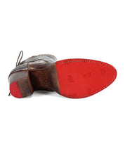 The Bia dress shoe by Bed|Stü, displayed from the bottom, features a red vegetable-tanned leather sole embossed with logos and a stacked wooden heel—demonstrating the meticulous craftsmanship inherent in handcrafted footwear.