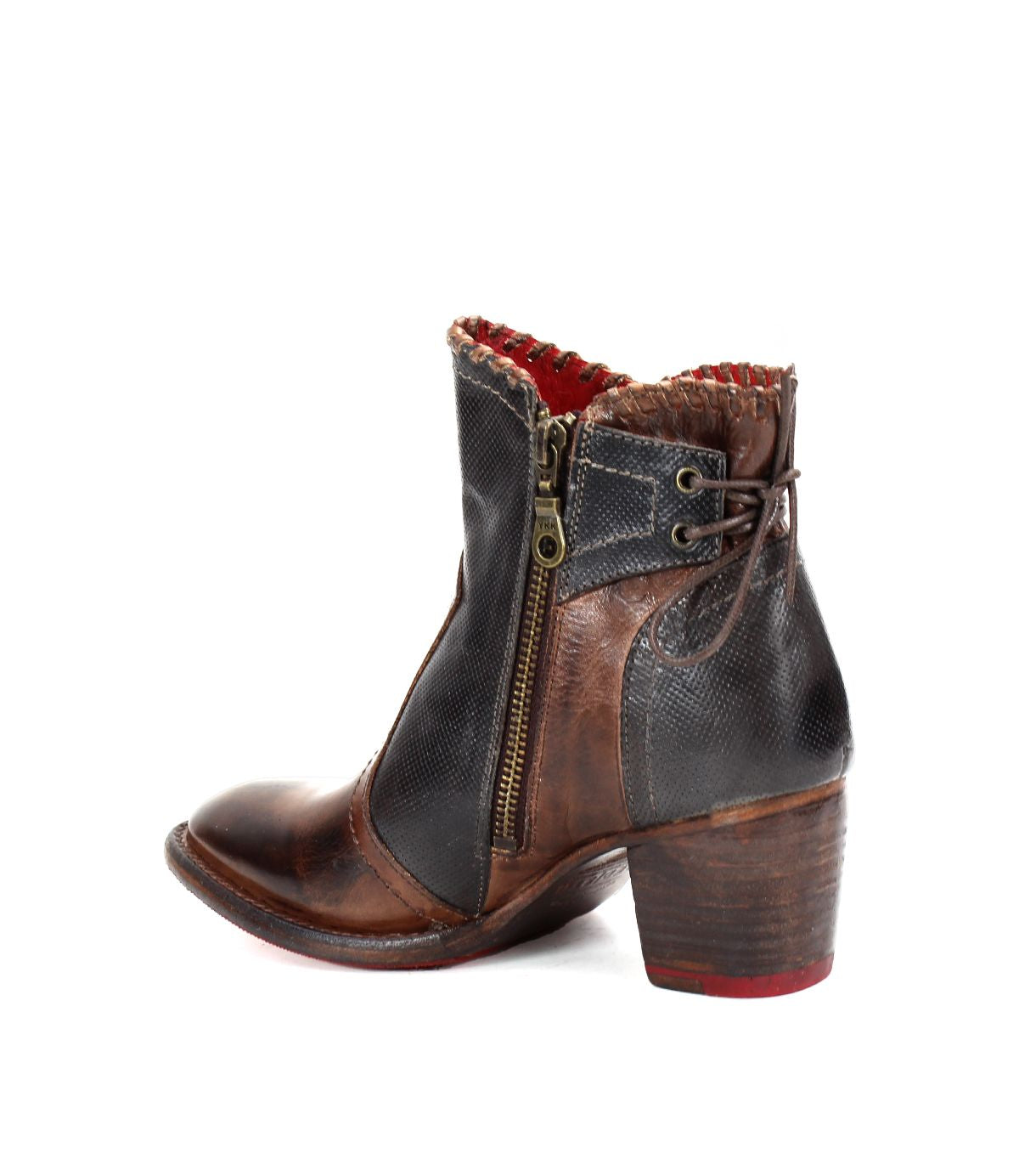 Introducing the Bia ankle boot by Bed|Stü, expertly handcrafted from premium vegetable-tanned leather in striking brown and black hues. This boot showcases a convenient side zipper, rich red interior lining, a stacked heel, and detailed decorative stitching for added flair.