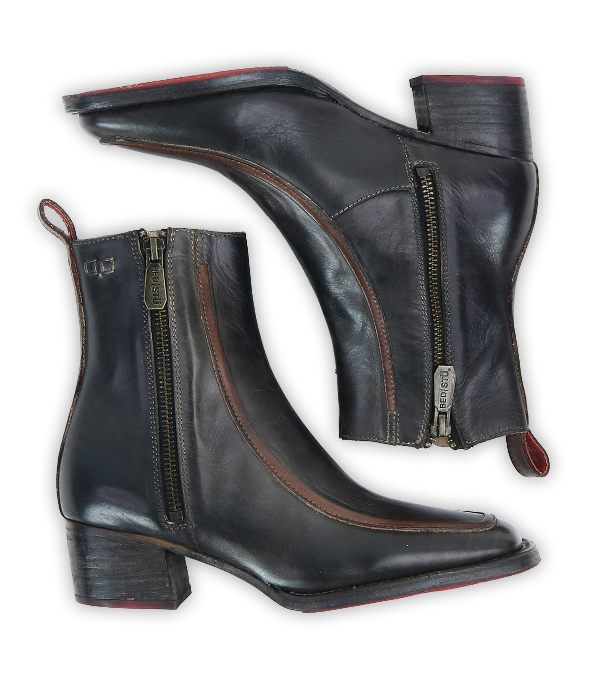 A pair of Bed|Stü "Bitsy" black leather ankle boots with brown accents, side zippers, low stacked heels, and red pull tabs, displayed from the side against a white background.
