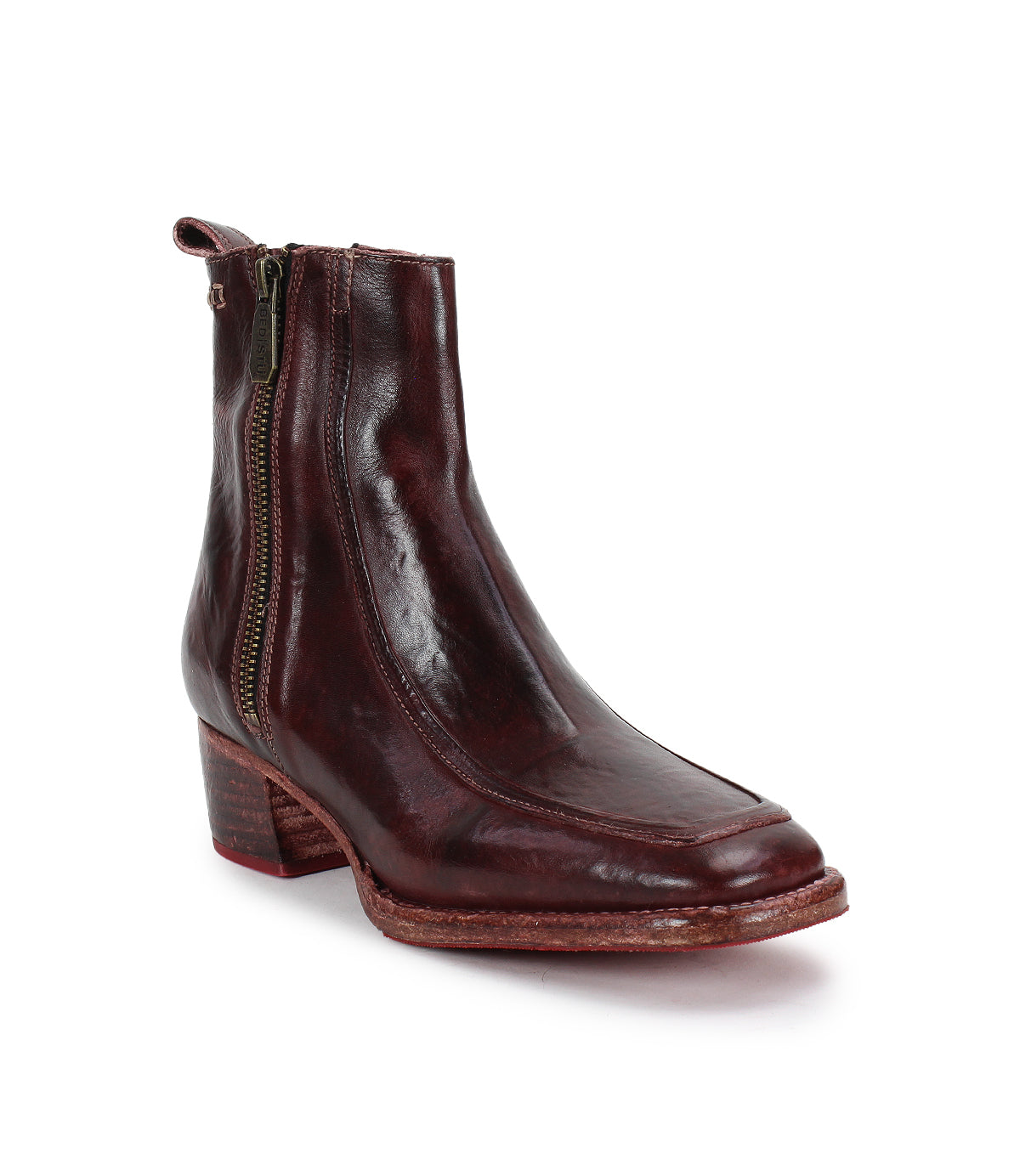 The Bed|Stü Bitsy is a brown leather ankle boot featuring a side zipper, stacked heel, and slightly pointed toe, displayed against a white background. This stylish design blends classic elements with modern comfort.