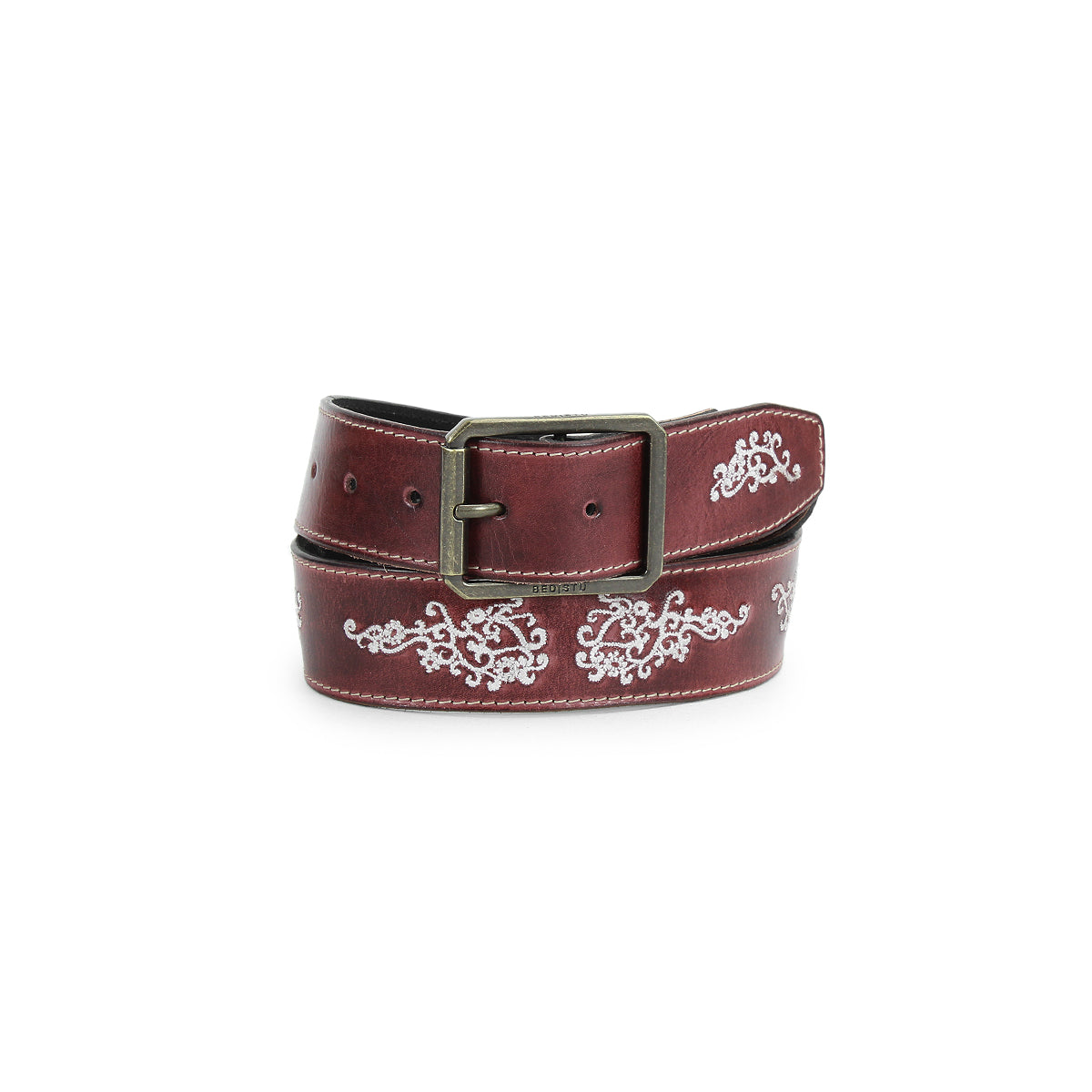The Blaze JB by Bed|Stü, a brown full-grain leather belt featuring an antique-finished buckle and white embroidered scrollwork floral designs, is shown coiled on a white background.