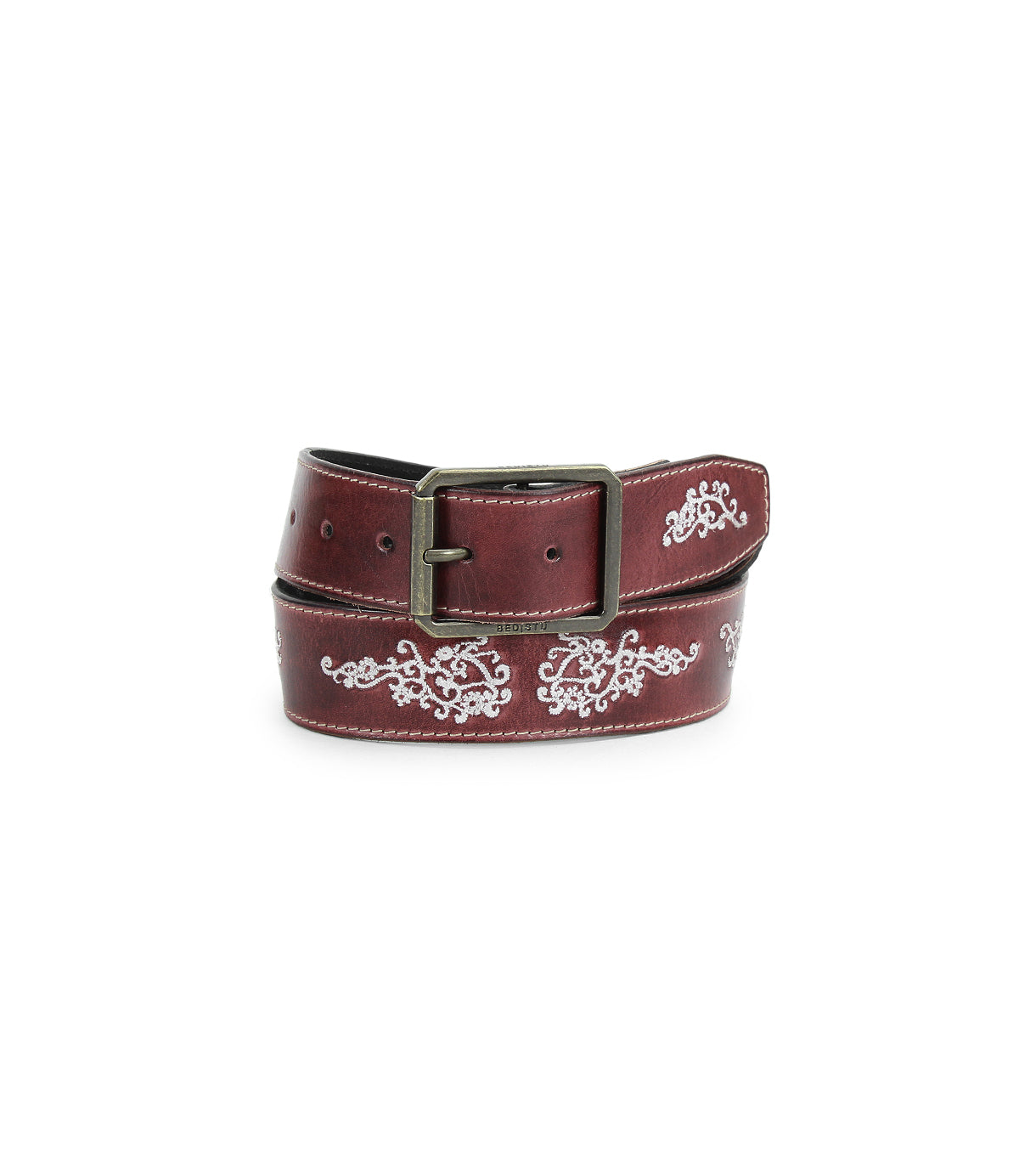 The Blaze JB by Bed|Stü, a brown full-grain leather belt featuring an antique-finished buckle and white embroidered scrollwork floral designs, is shown coiled on a white background.