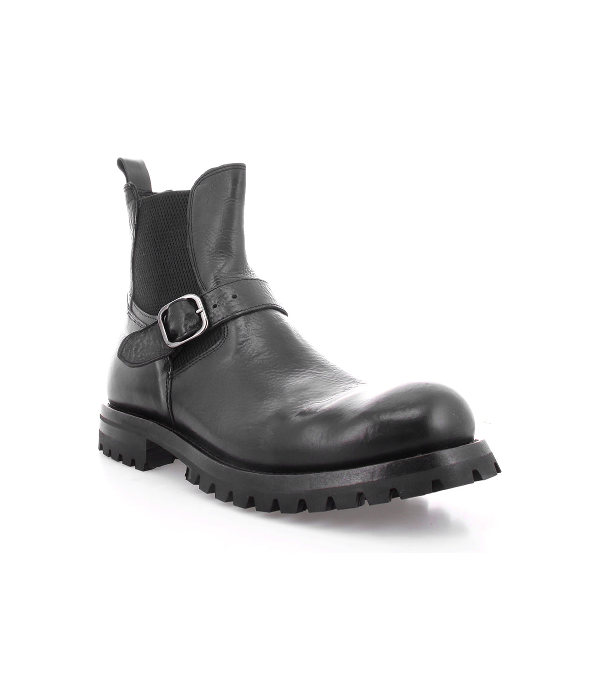 Boast by Bed|Stü is a black leather ankle boot crafted from full-grain leather, featuring a side buckle, elastic panel, pull tab, and thick rubber lug sole—shown on a white background. This classic men's Chelsea boot combines the enduring quality of Italian leather boots with modern details for everyday wear.