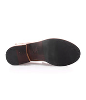 The photo shows the bottom view of a single Bed|Stü Bonus dress shoe featuring a dark rubber sole and a wooden heel, exemplifying the classic style often found in Italian leather penny loafers.