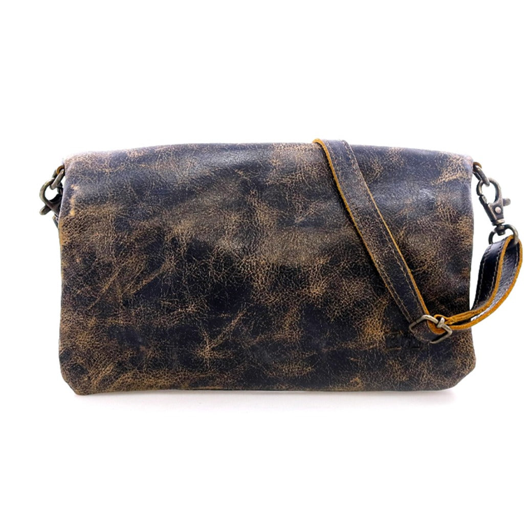 The Cadence shoulder bag by Bed|Stü features distressed brown vegetable-tanned leather, a long adjustable strap, and metal clasps, shown here against a white background.