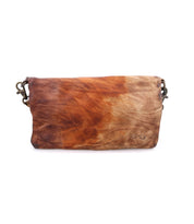 The Bed|Stü Cadence is a rectangular brown vegetable-tanned leather clutch featuring a marbled texture and two small metallic rings at either end for attaching a strap—perfect for carrying as a crossbody, clutch, or transforming into a versatile 3-in-1 leather wallet.