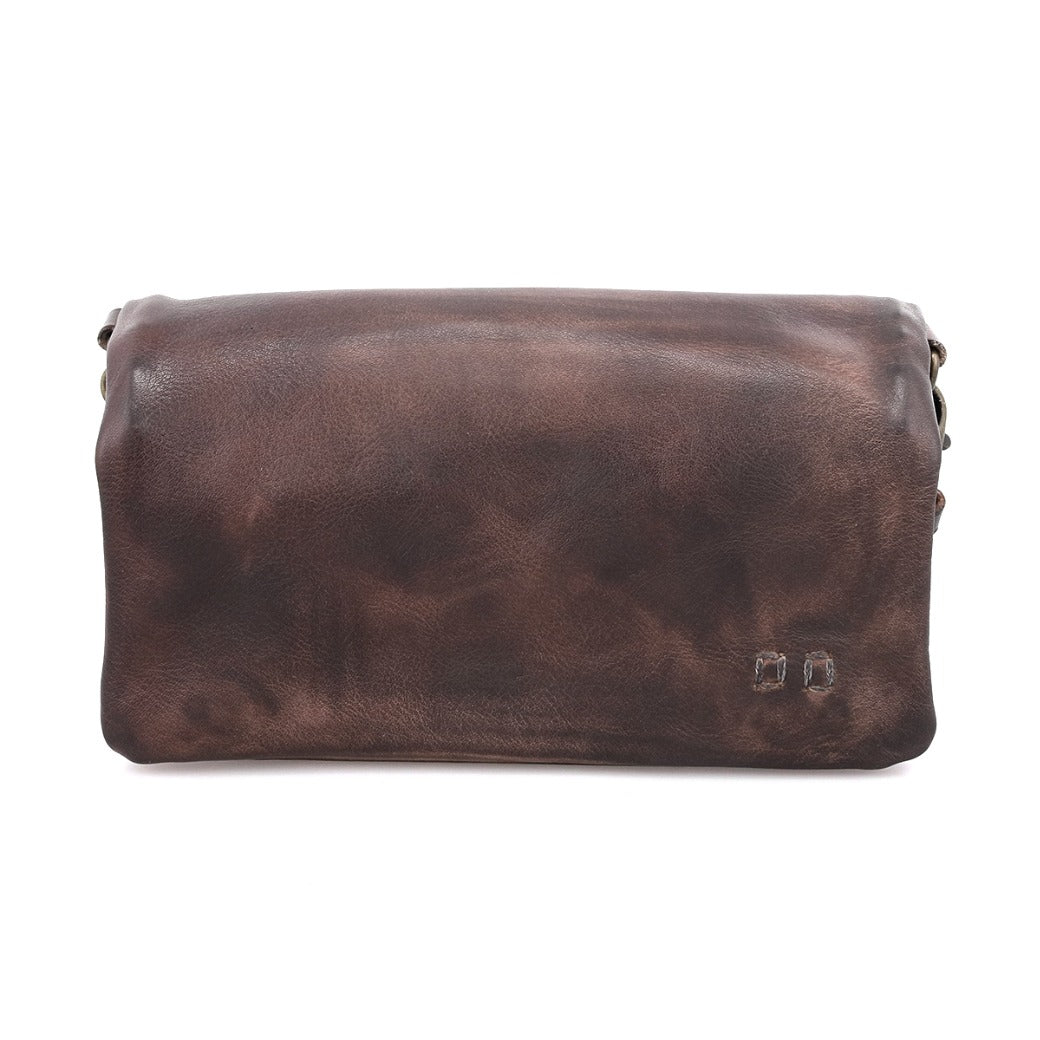 The Cadence pouch by Bed|Stü is a rectangular brown accessory, crafted from vegetable-tanned leather featuring a smooth, slightly worn finish and accented with two small metal rivets on the lower right corner, displayed against a white background.