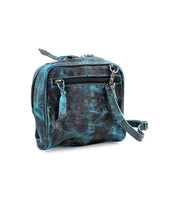 The Capture by Bed|Stü is a small, square-shaped crossbody bag handcrafted from black and teal marbled leather, featuring a front zipper pocket and an adjustable strap, shown here on a white background.