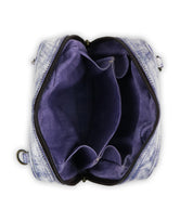 Top view of an open, empty Bed|Stü Capture handcrafted purse featuring a purple interior, multiple compartments, visible zippers, and part of a strap on one side, set against a white background.