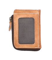 The Carrie wallet by Bed|Stü showcases a compact leather design with brown zippered construction, tan leather edges, a central fabric panel, and white stitching. This stylish accessory features convenient card slots and a secure zip compartment, presented against a white background.