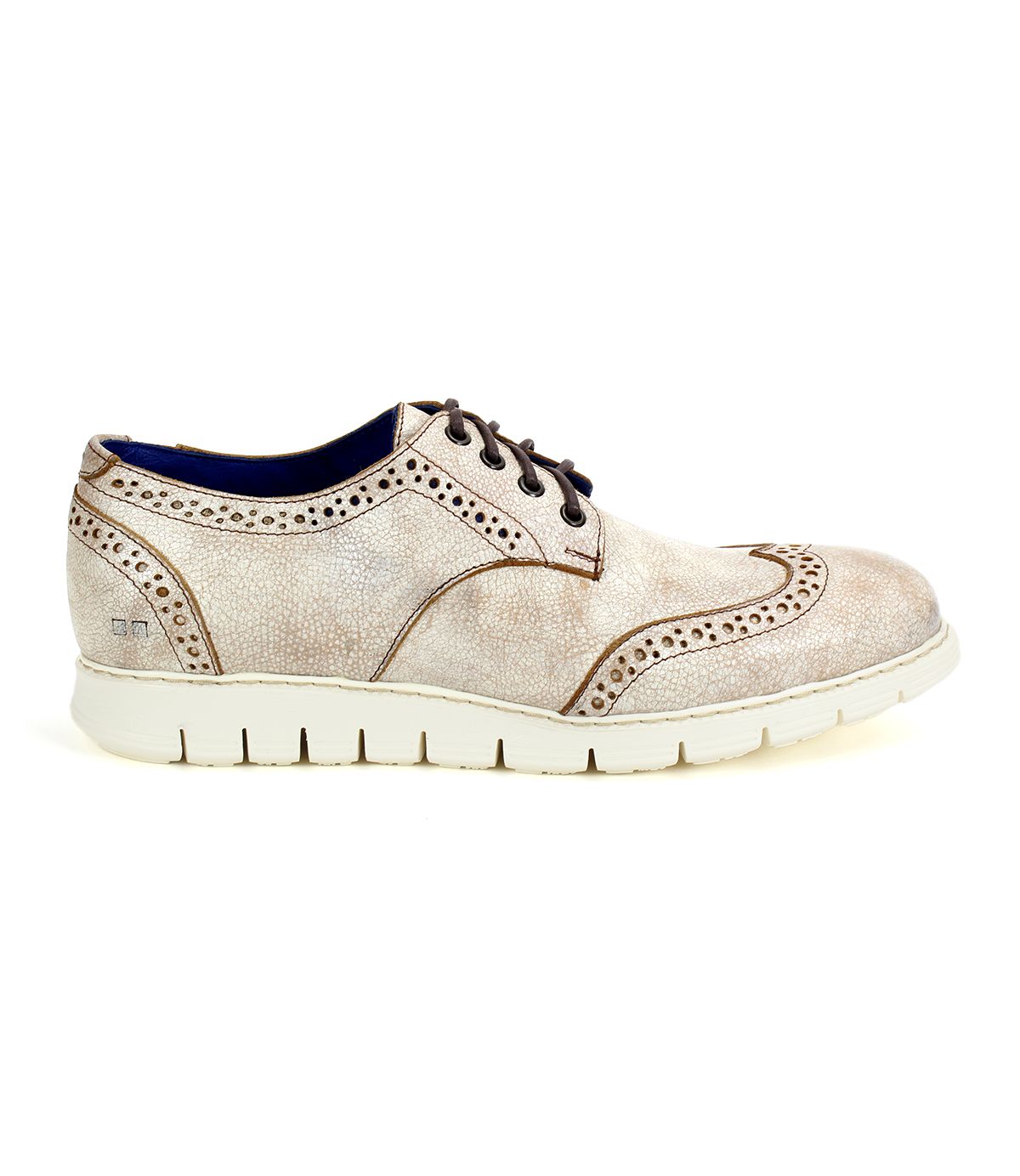 The Bed|Stü Cayuga II is a light beige suede wingtip shoe featuring classic brogue detailing, dark brown laces, and a thick white rubber sole, shown in profile view.
