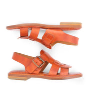Two Charka sandals by Bed|Stü are shown side by side on a white background. These orange woven leather sandals feature buckle closures and flat soles.