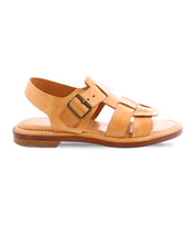 The Charka sandal by Bed|Stü features tan woven vegetable vacchetta leather with an open toe, closed heel, buckle strap, and a flat sole, displayed in a left side profile against a white background.