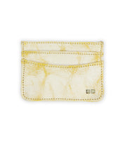 The Bed|Stü Chuck is a cream-colored leather card holder featuring yellow marbling, visible stitching, and two small square metal accents in the bottom right corner—making this compact card wallet perfect for everyday carry.