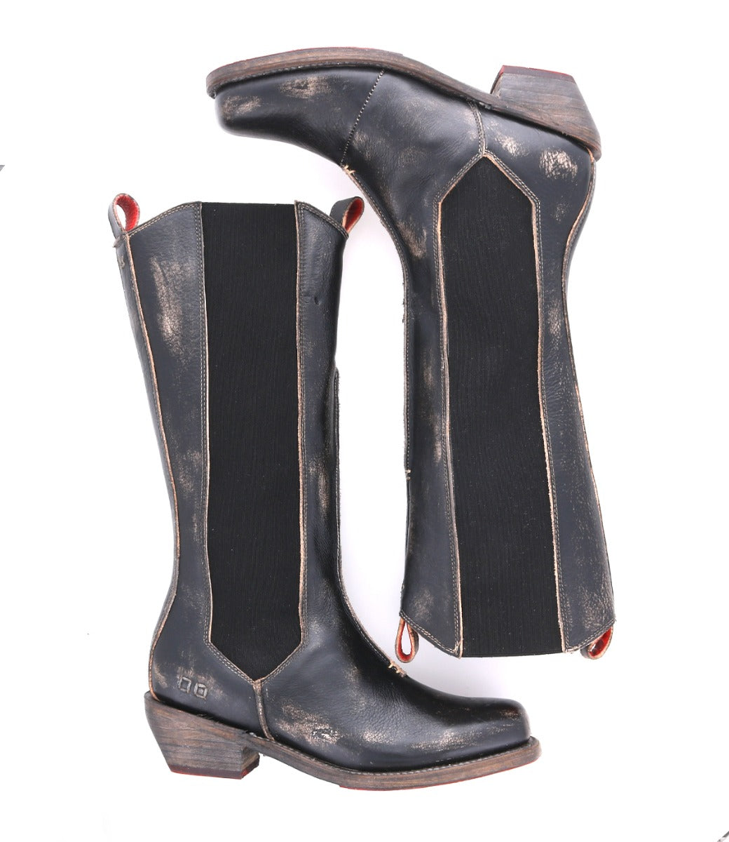A pair of Clarisse black distressed leather cowboy boots by Bed|Stü, featuring pull tabs, elastic side panels, and stacked western heels, displayed side by side in a classic mid-calf tall boot silhouette.
